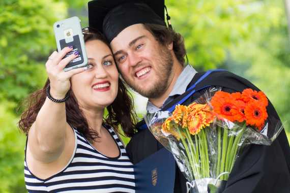 Family member gives flower bouquet to a UBC graduate